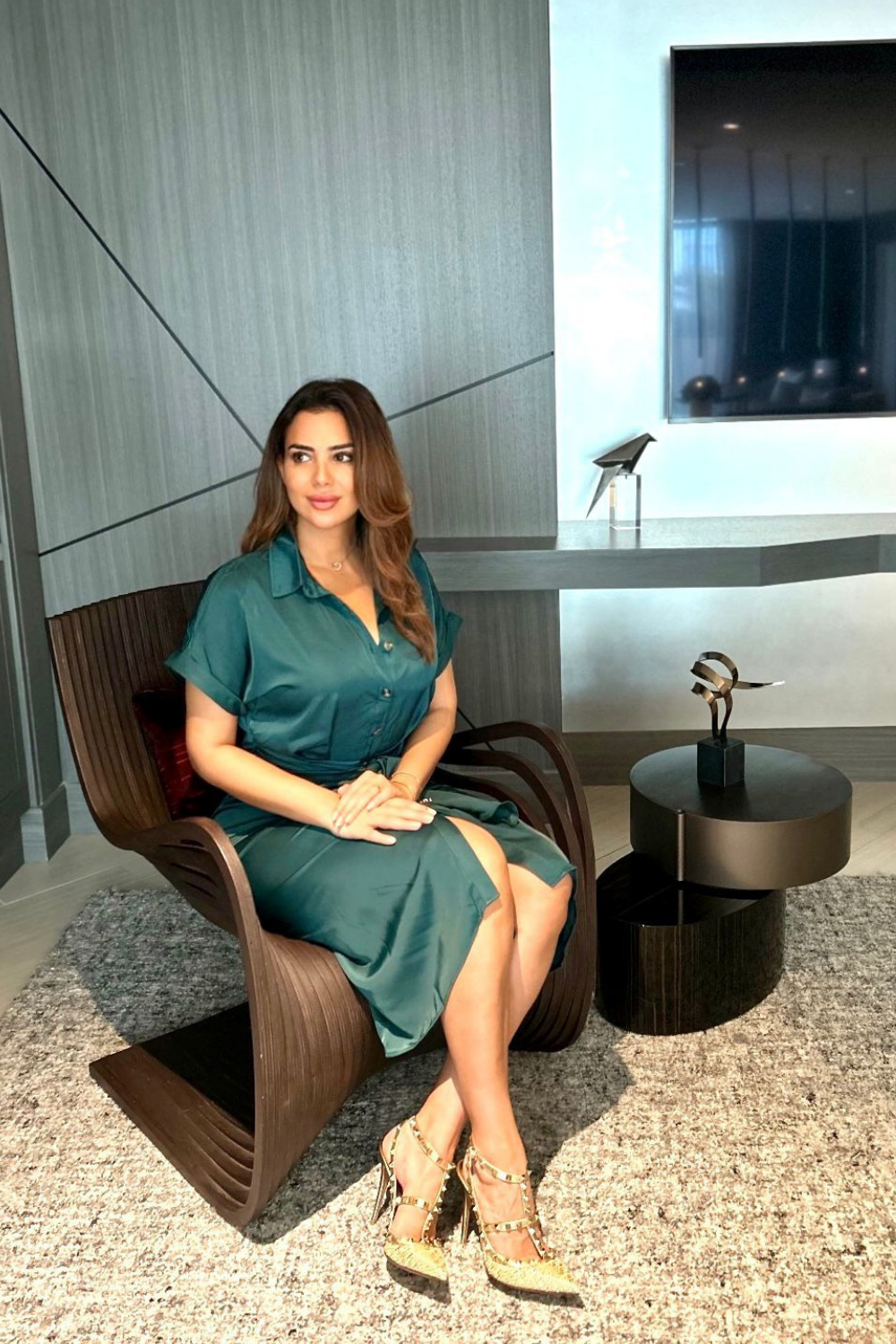 Dr. Sarah Hadid, gracefully seated in a contemporary office setting with modern decor